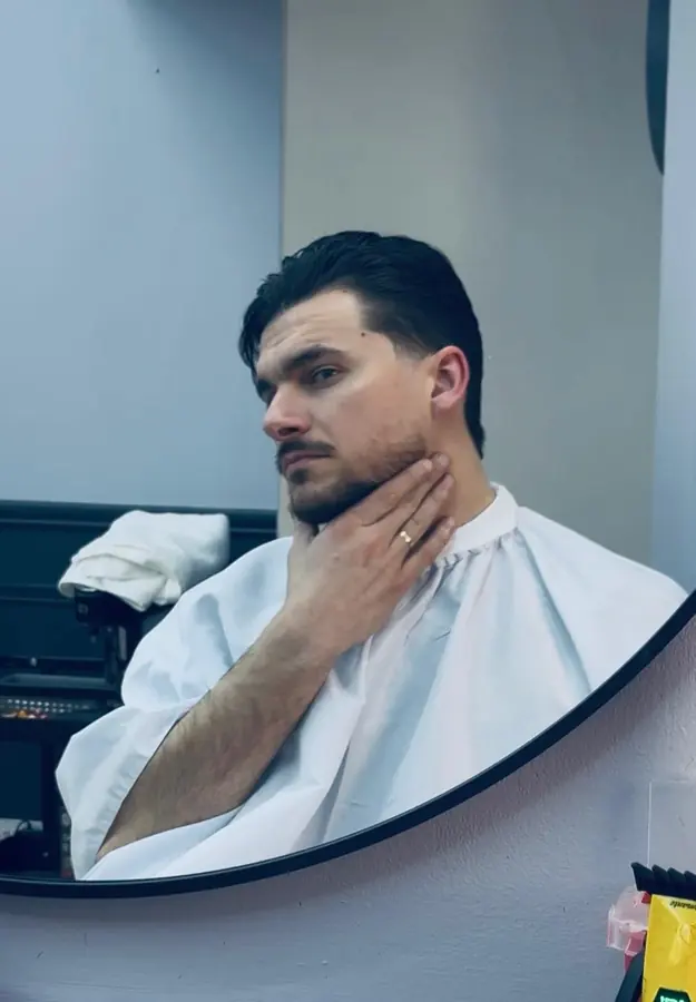 Client checking beard and haircut in the mirror