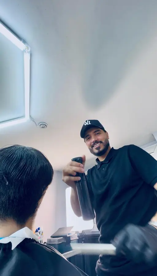 Barber applying finishing spray during a haircut