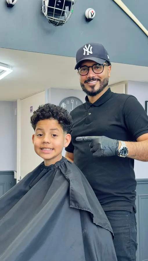 Barber and young client smiling after a haircut