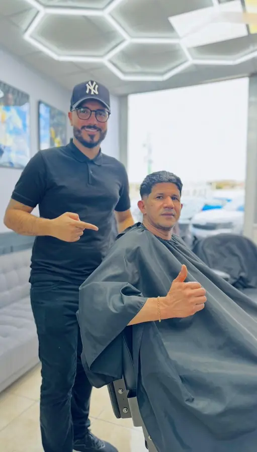 Barber and client inside the shop after a cut